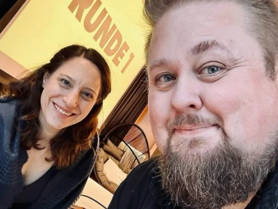 Workshopleitende Kora und René vor einer Beamerleinwand – darauf steht Runde 1