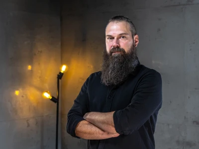 Porträt von Andre Junkersdorf mit verschränkten Armen.