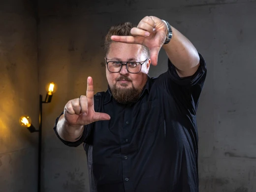 René deutet mit seinen Fingern ein Rechteck in der Luft ab.