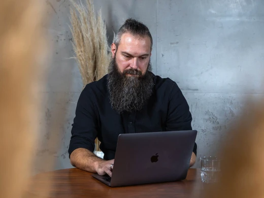 Andre am Tisch mit Laptop