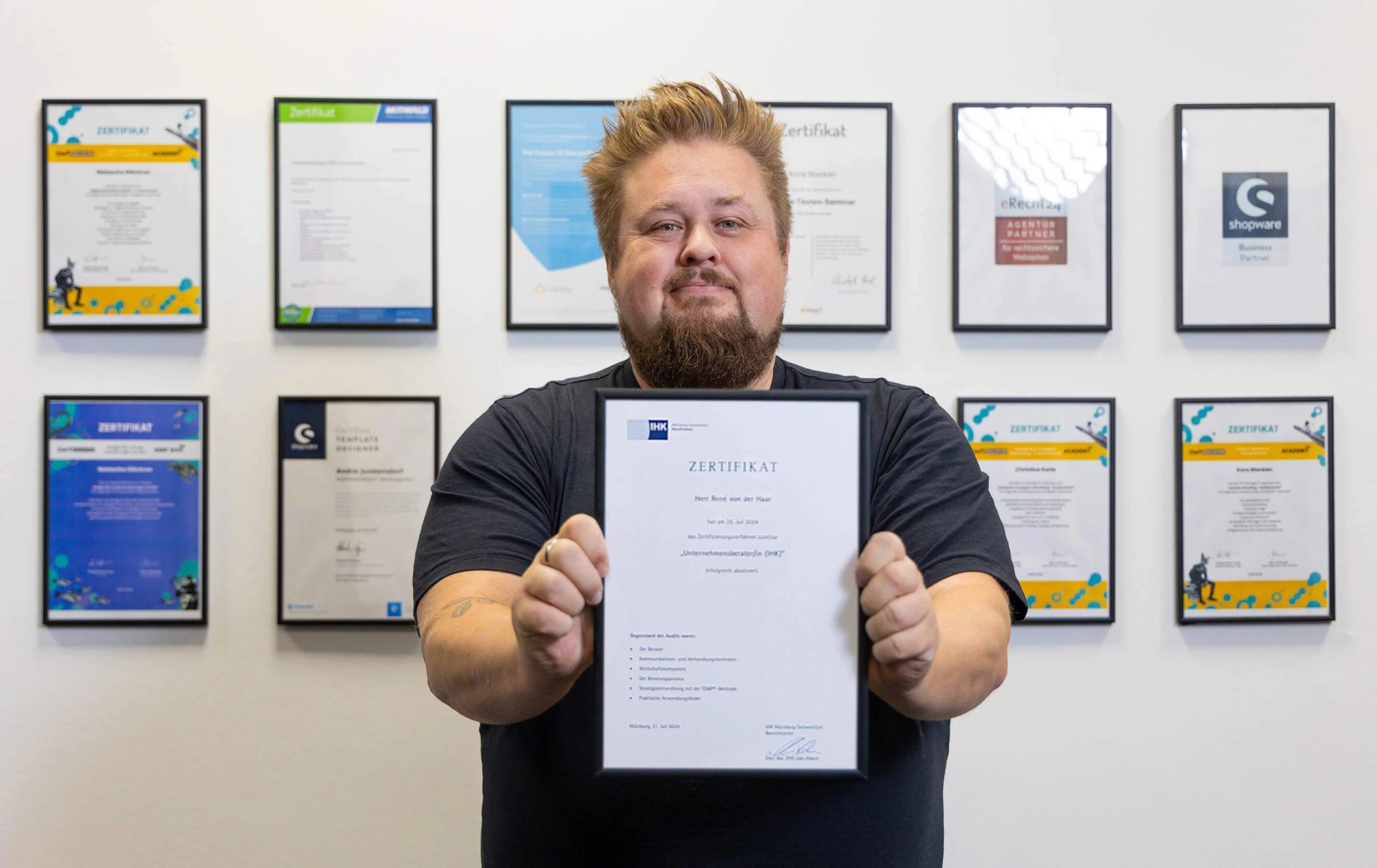 René hält sein IHK Unternehmensberater Zertifikat hoch