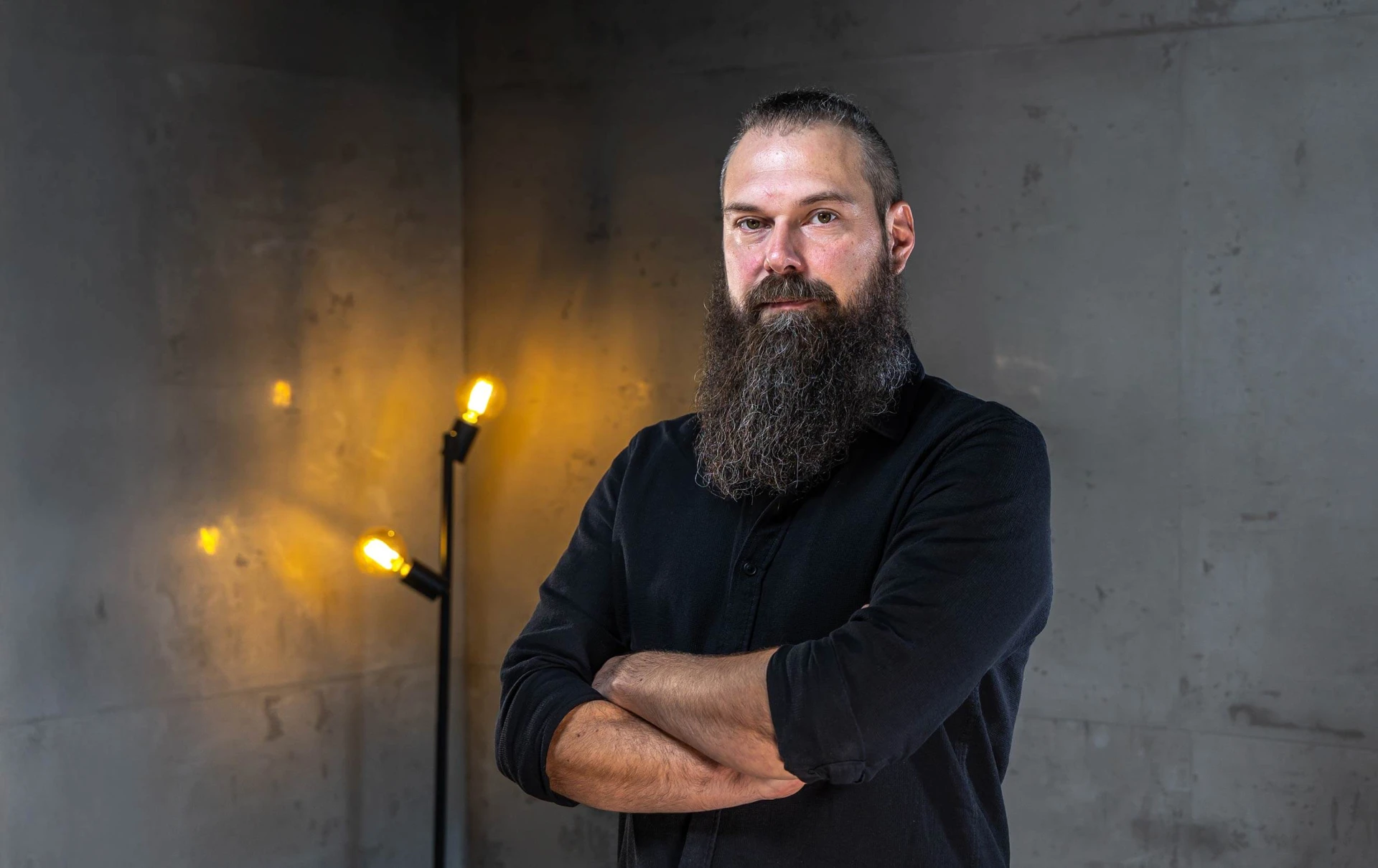 Porträt von Andre Junkersdorf mit verschränkten Armen.