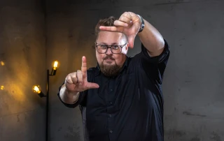 René deutet mit seinen Fingern ein Rechteck in der Luft ab.