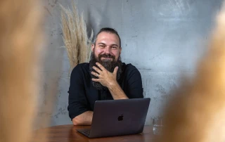 Andre am Tisch mit Laptop